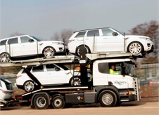 side view of an Acumen car transporter transporting white Range Rover Sport's