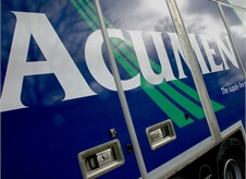 close up view of Acumen Logistics logo on the side of one of its covered car transport lorries