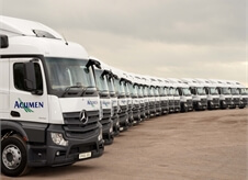 side view of a large number of new Acumen Logistics lorries all lined up in a slight curve